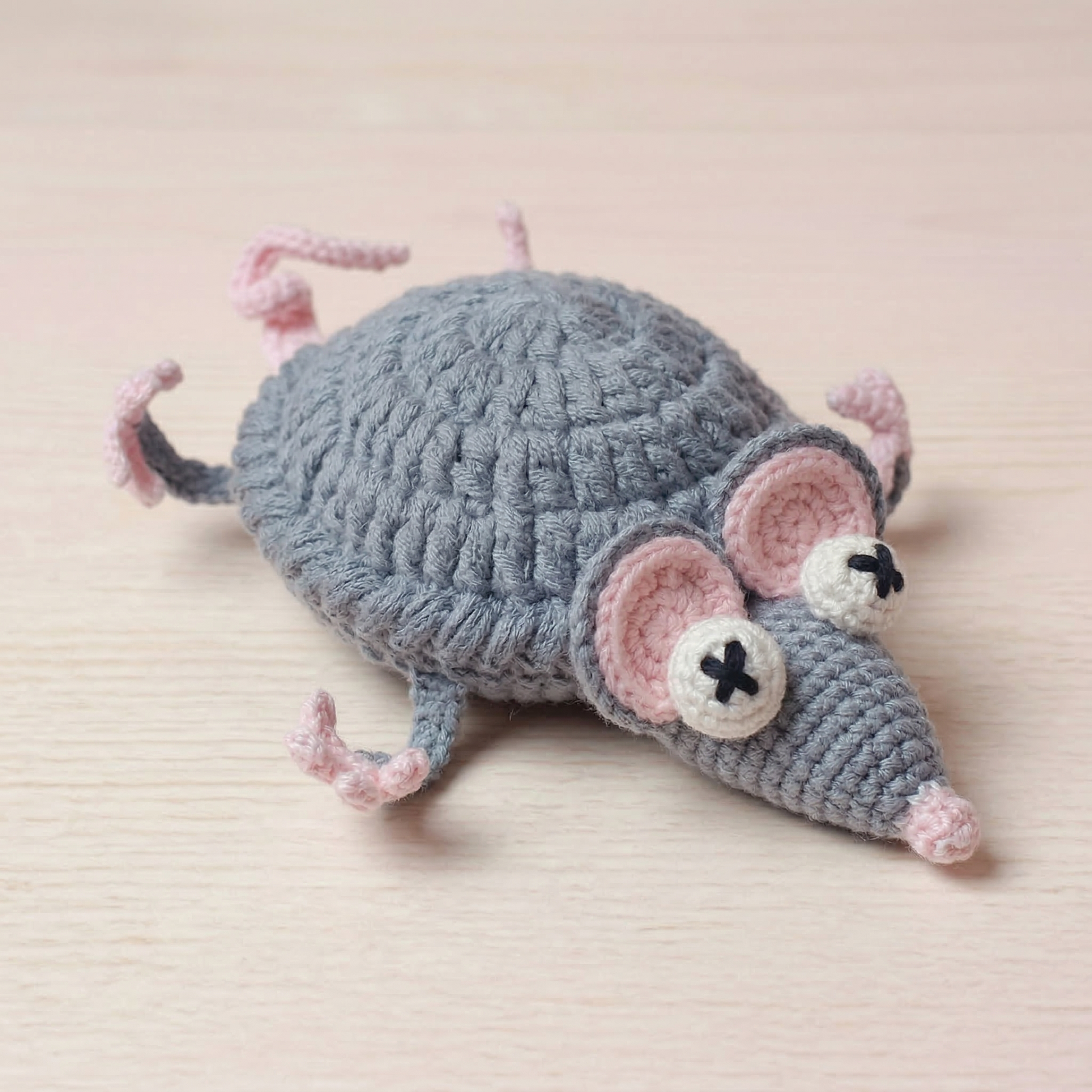 Crocheted mouse toy on a beige background