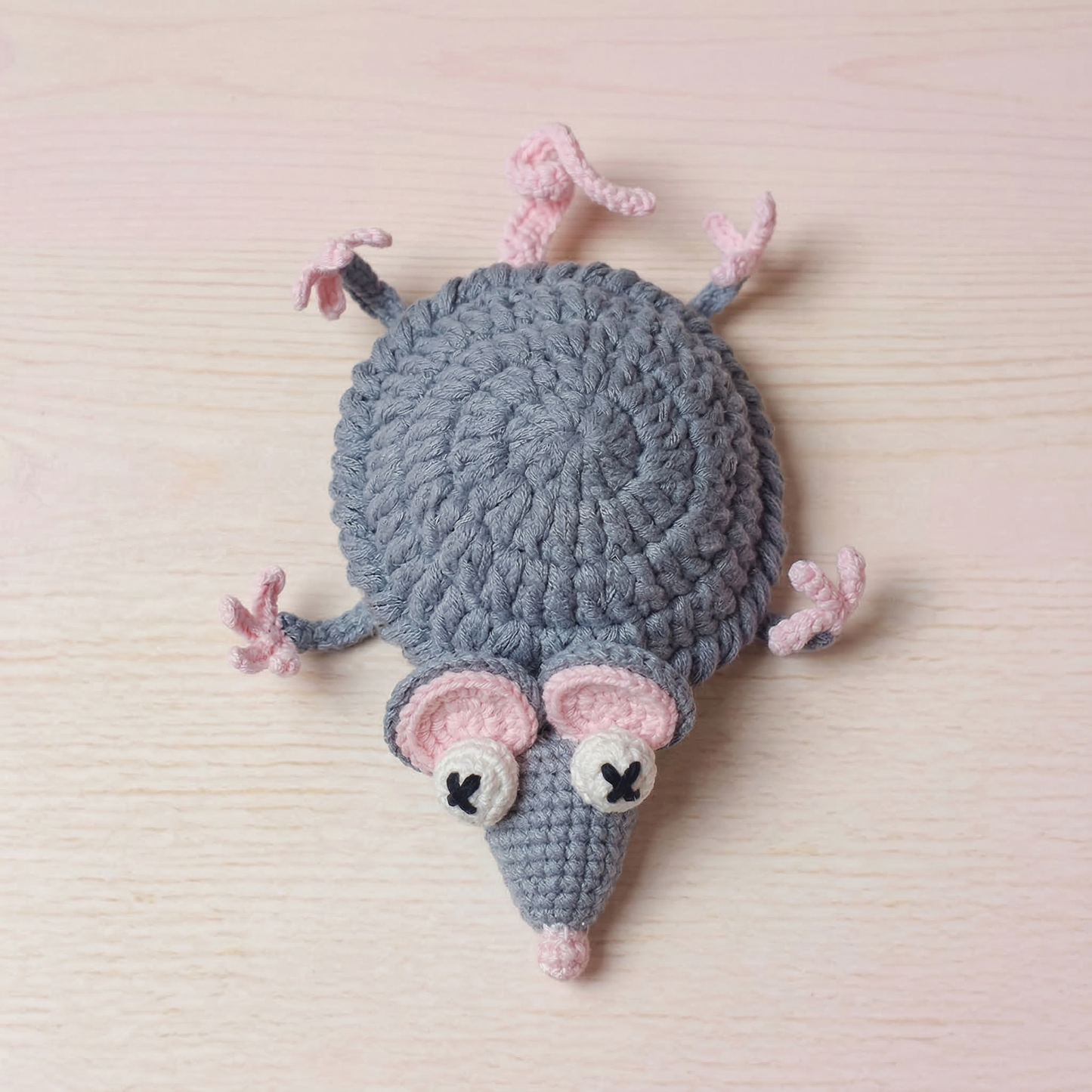 Crocheted mouse toy on a light wooden surface